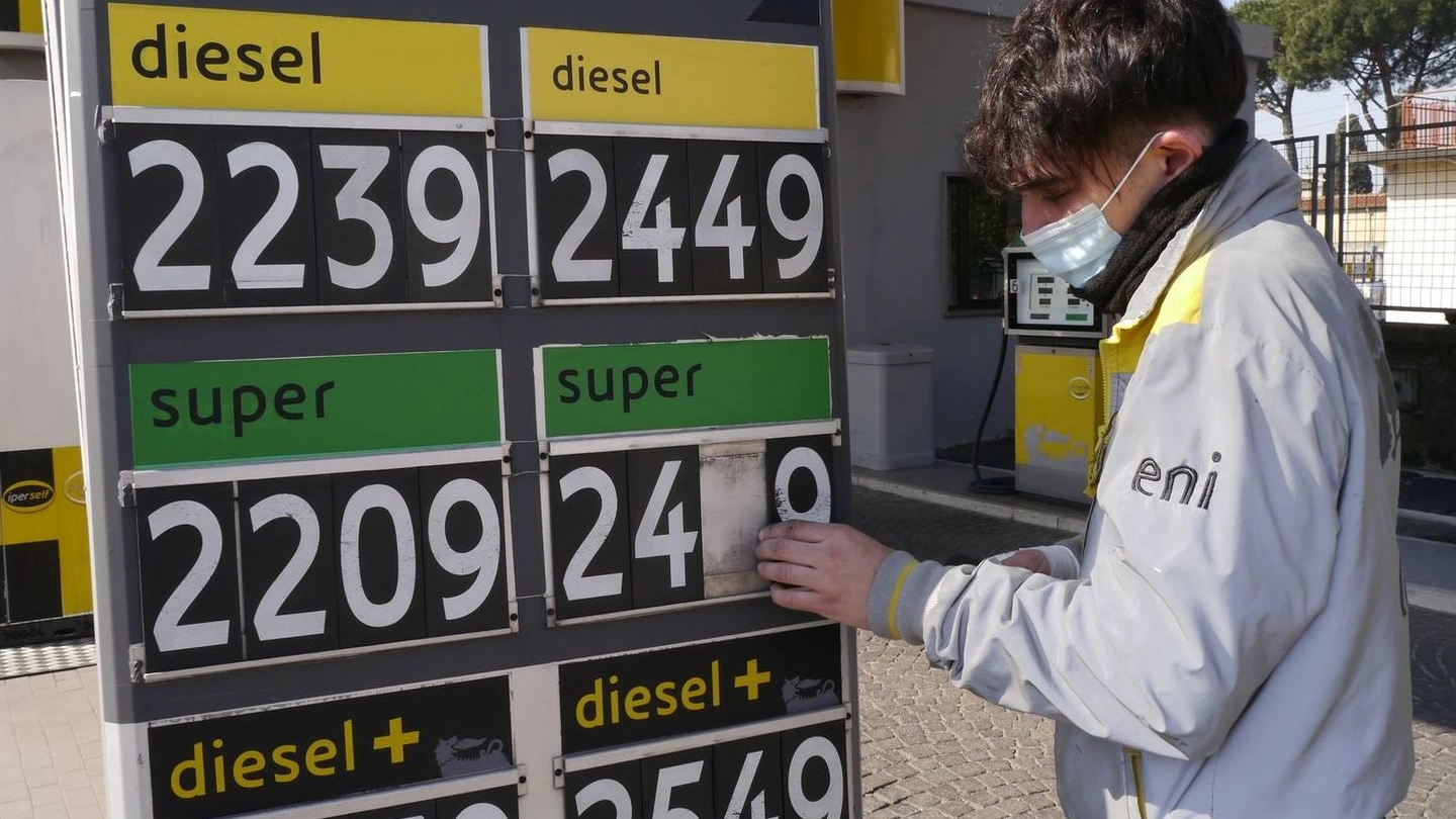 Un benzinaio mentre aggiorna i prezzi dei carburanti