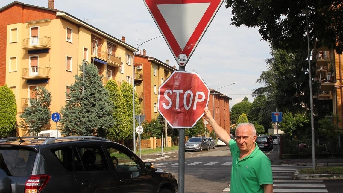 Un residente mostra il cartello artigianale dello stop affisso in via Casoni (Isolapress)