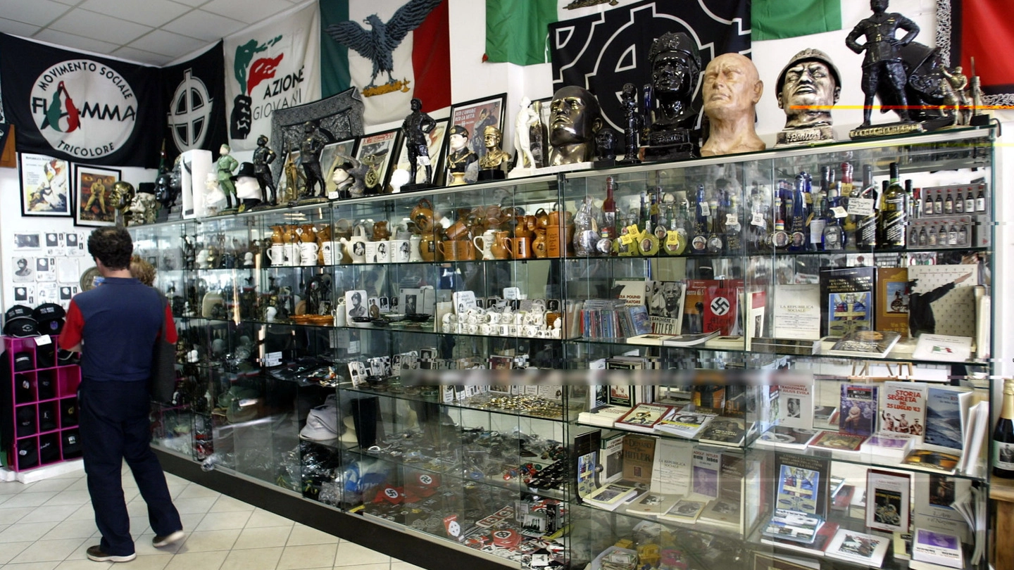 SOUVENIR IN VETRINA Alcuni dei numerosi oggetti e bandiere in vendita nella città di Mussolini (Frasca)