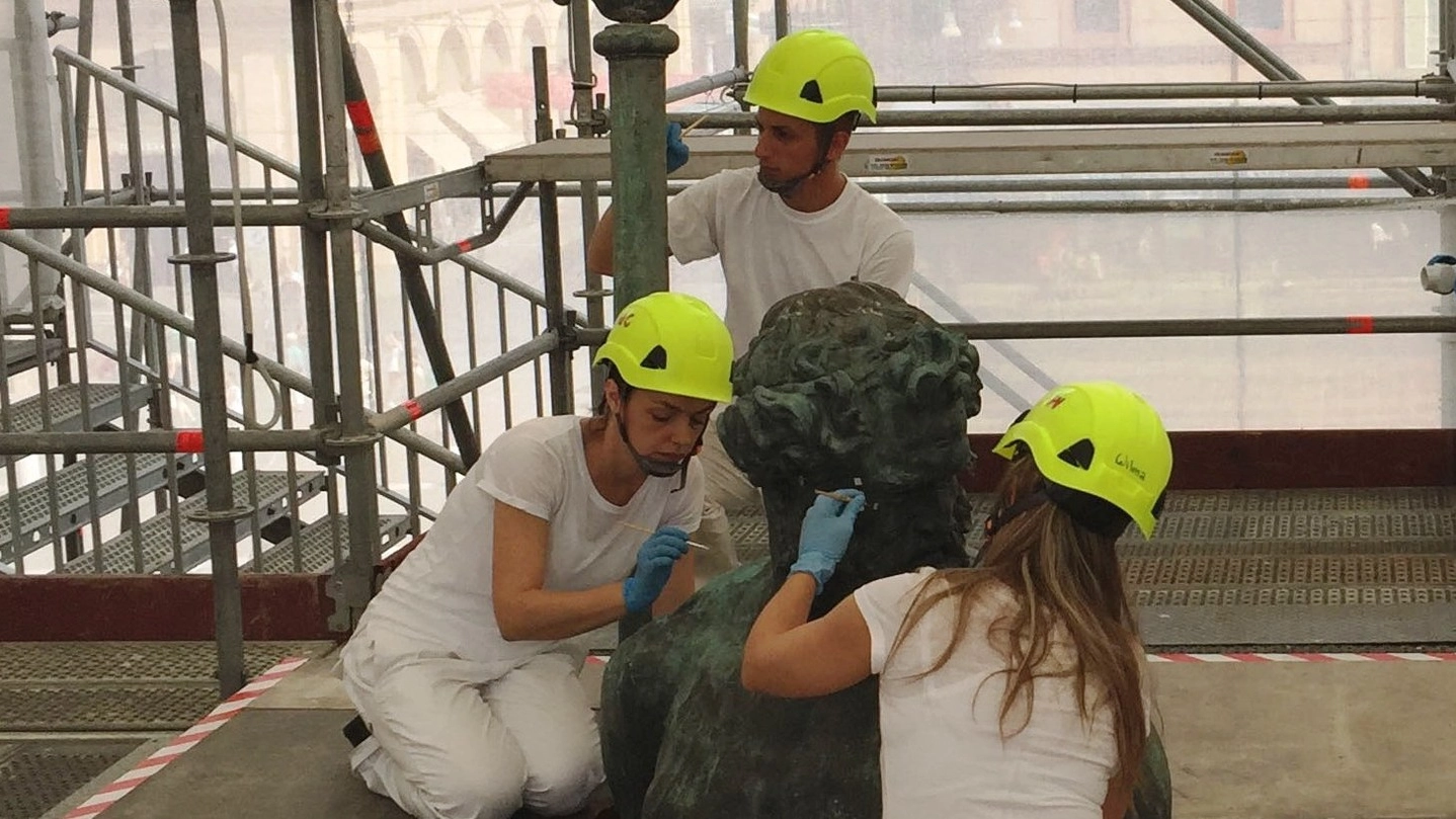 I restauratori al lavoro sulla statua del Nettuno