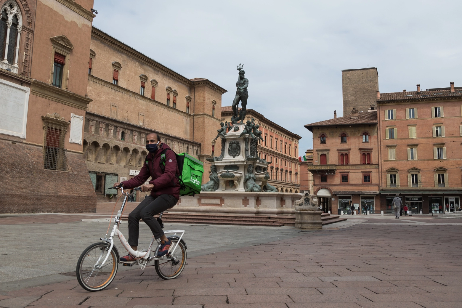 Un addetto delle consegne in bici in piazza Maggiore (foto d'archivio)