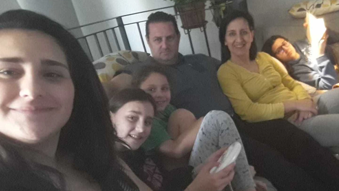 Andrea Botti e la moglie con i figli nel divano di casa