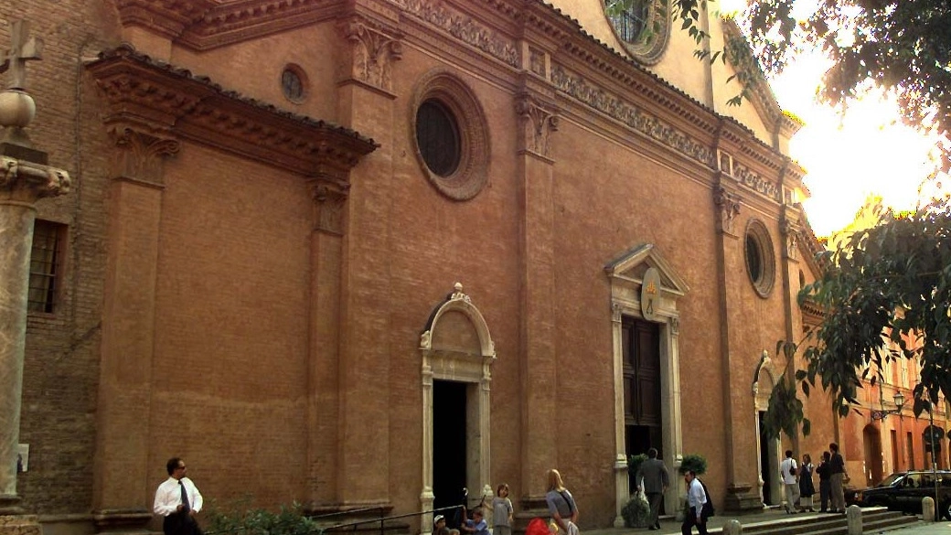 La facciata dell’abbazia di San Pietro. Nel tondo, l’ex parroco, monaco benedettino come l’aggredito, don Gregorio Colosio