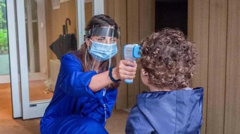 Il controllo della febbre con lo scanner su una bambina all'asilo