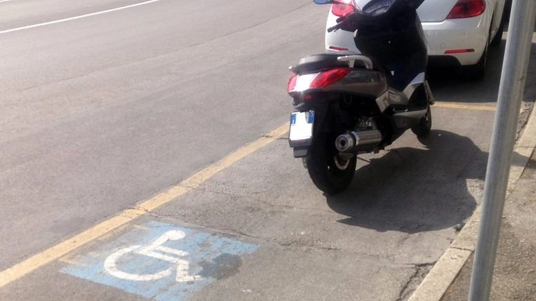 NEL MIRINO Un parcheggio per disabili occupato abusivamente da uno scooter: la violazione è stata fotografata da un cittadino e pubblicata sulla pagina ‘Facebook’ lanciata da Francesco Tonti