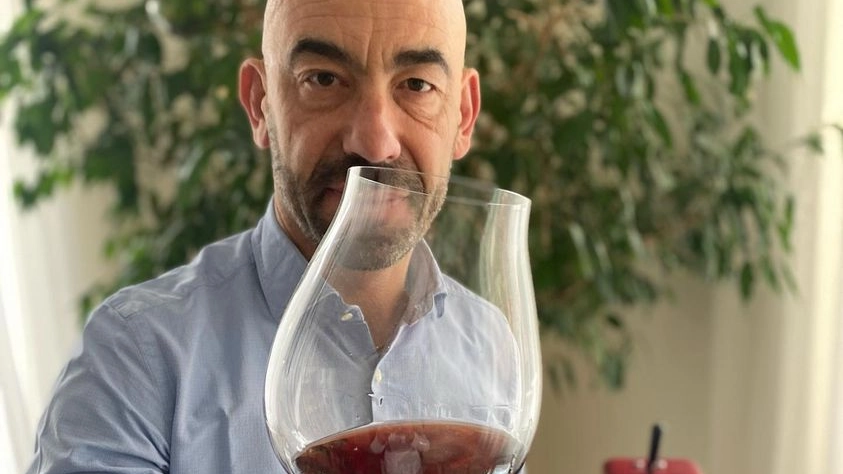 Matteo Bassetti brinda con un bicchiere di vino rosso contro l'ipotesi di scrivere sulle bottiglie "nuoce alla salute"
