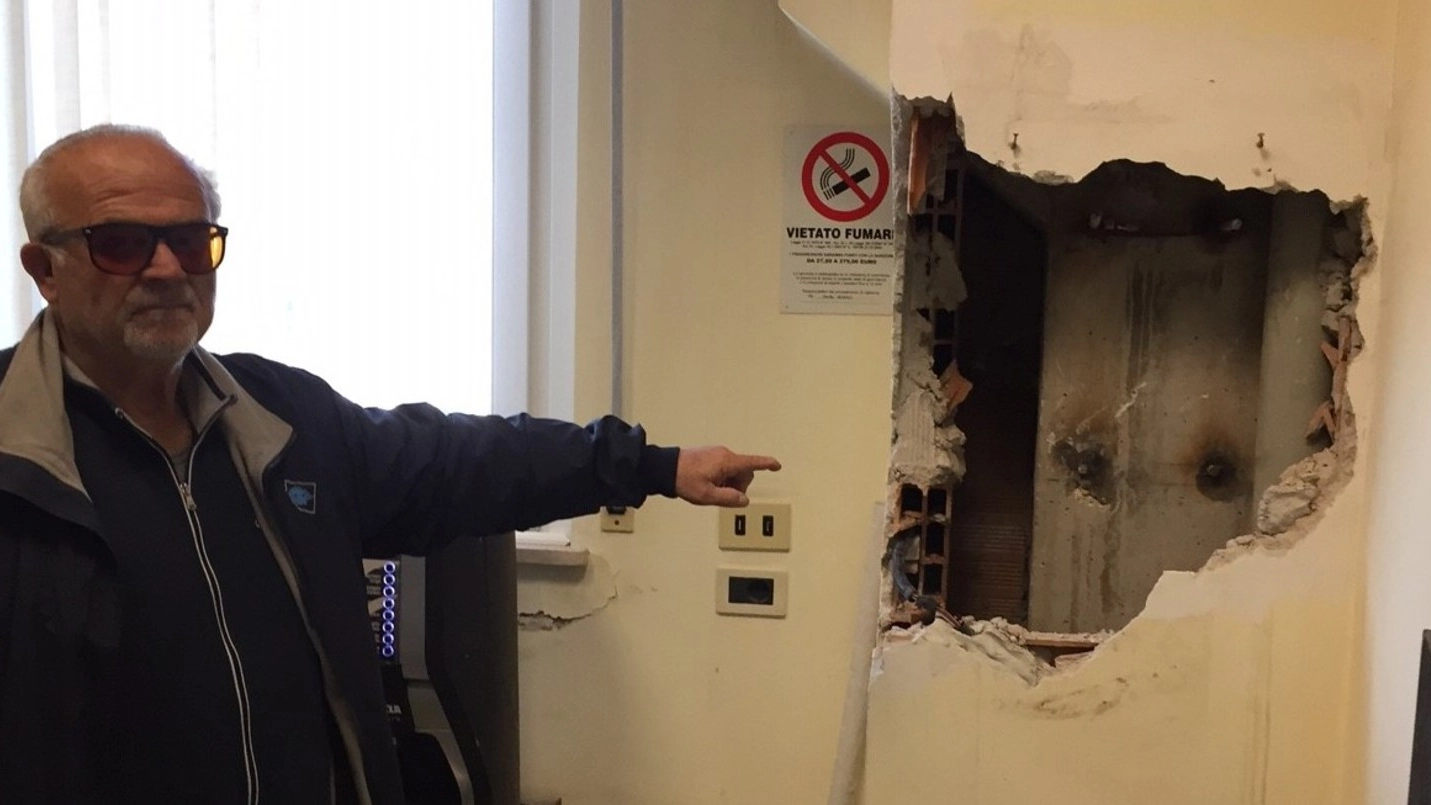 Nicola Romagnoli indica lo squarcio aperto dai ladri nella parete degli uffici per smurare la cassaforte