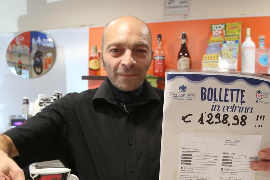 Michele Paparella del Blu Bar di Cesena mentre mostra l’aumento in bolletta