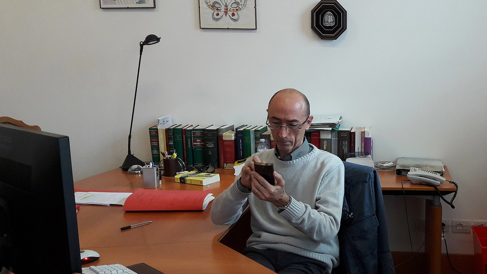 Il giudice del Lavoro Maurizio Paganelli mentre consulta l'agenda elettronica sul telefono