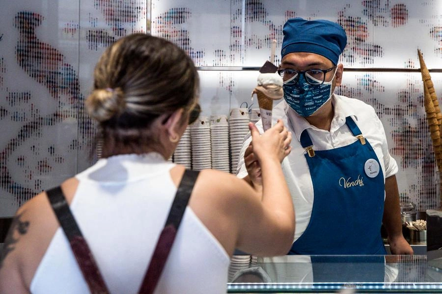 Un dipendente di una gelateria di Roma indossa la mascherina (Ansa)