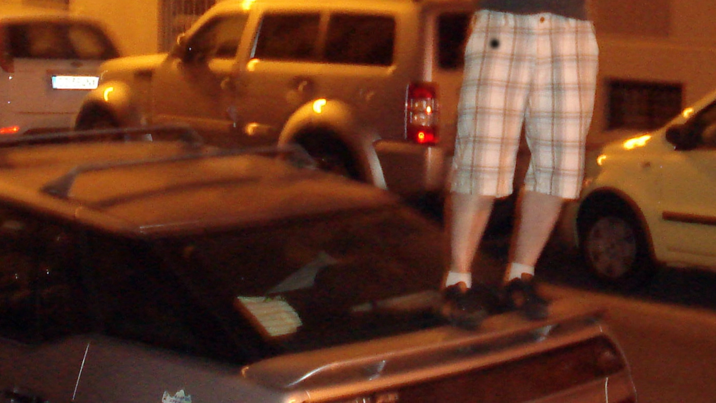 Un giovane sopra un’auto in una foto d’archivio Newpress