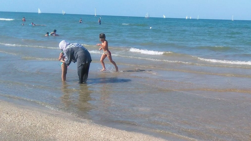La donna con il velo in spiaggia