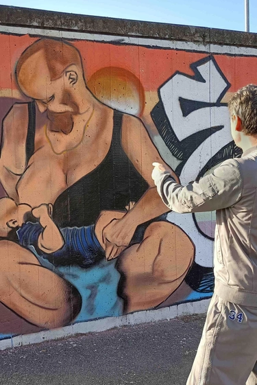 Il murales cancellato dell’uomo che allatta a Rimini, gli attivisti: “Lo rifaremo, la censura non ci fermerà”