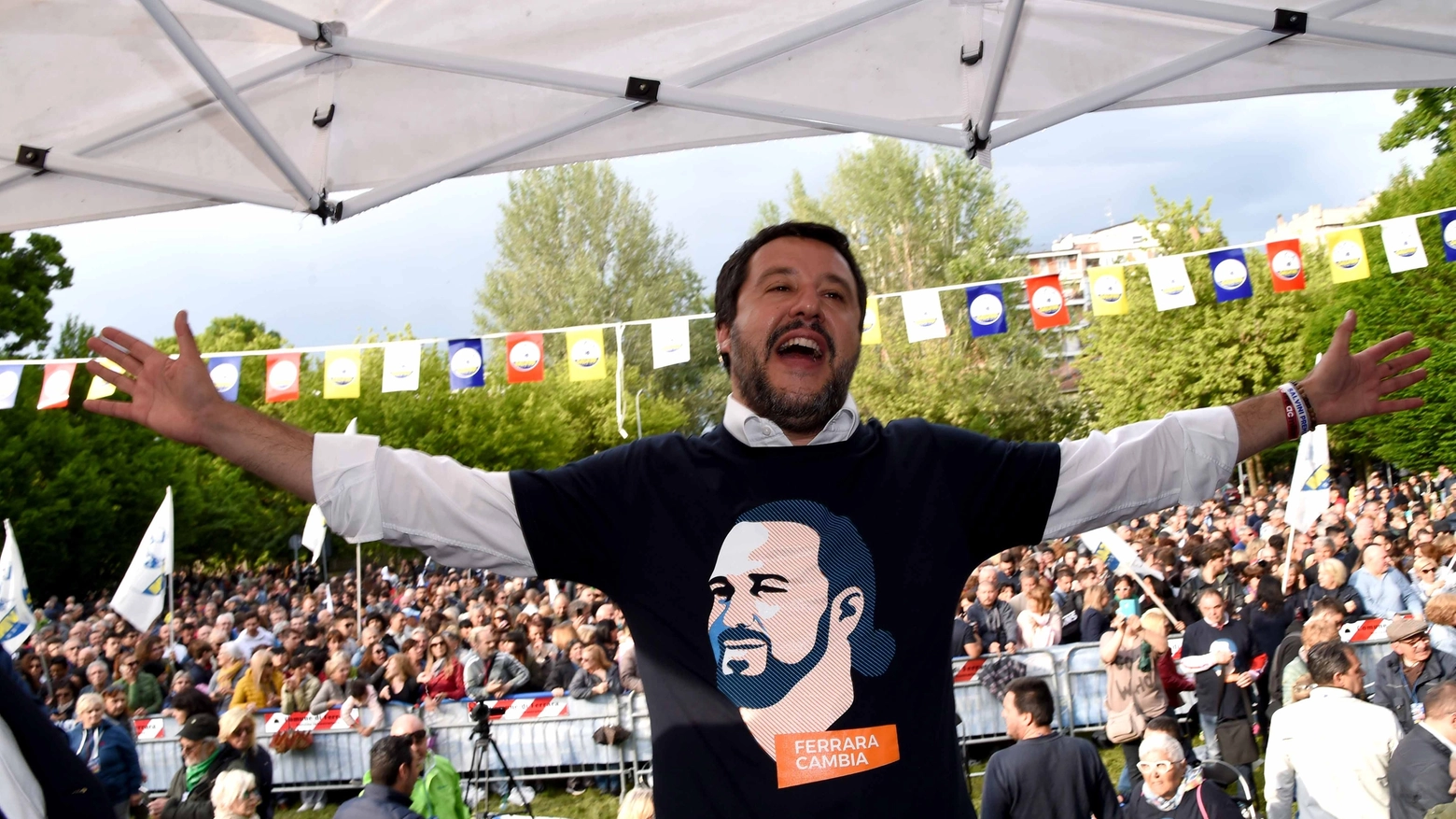Matteo Salvini sul palco a Ferrara; la maglia ha il volto del candidato Fabbri