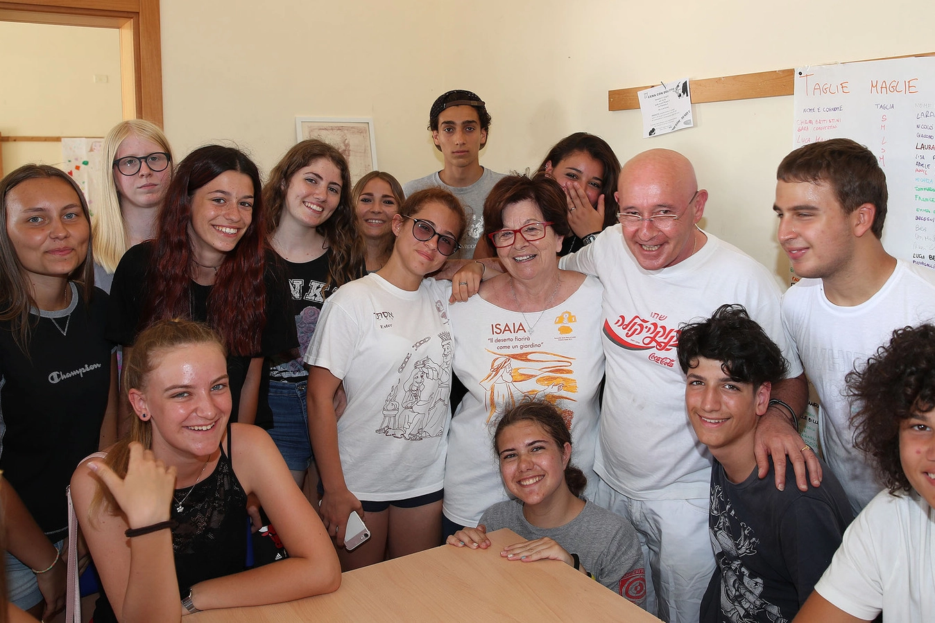 Don Peppe Fabbrini, a destra, al suo fianco una collaboratrice e il gruppo di educatori