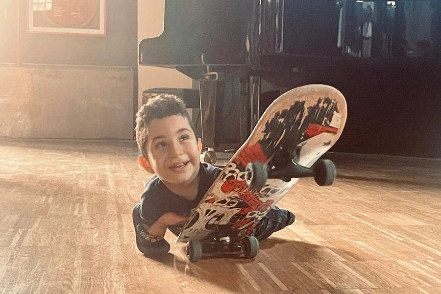 Il piccolo Mustafà sorridente sul suo skateboard