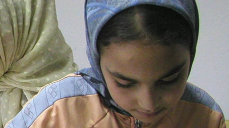 Una bambina studia la lingua araba