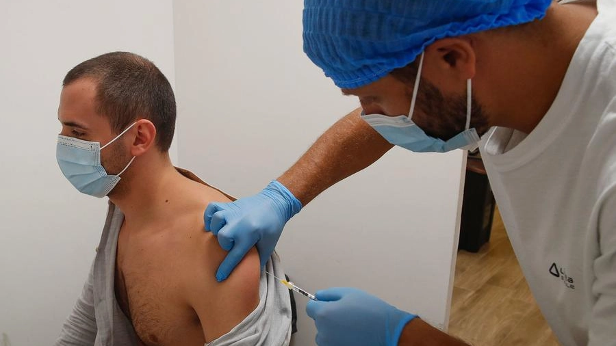 Un sanitario intento a inoculare il vaccino a un paziente (foto d’archivio)