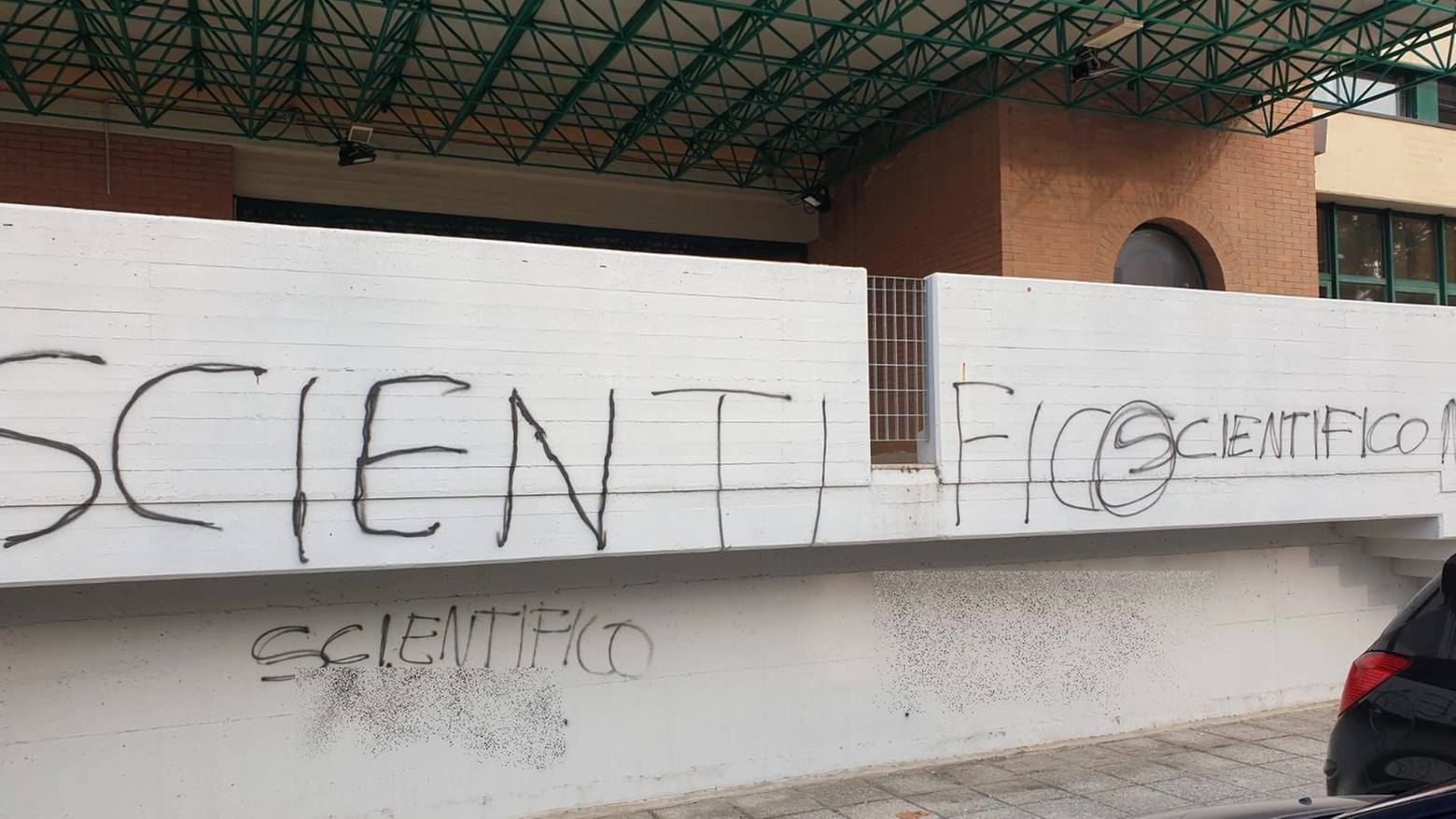 Le scritte dei vandali sui muri del liceo scientifico