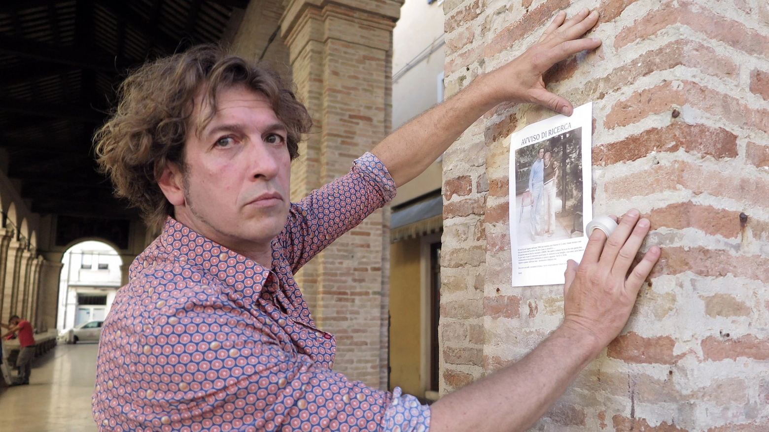 David Mossè mentre tappezza la città di foto alla ricerca del padre (foto Petrangeli)