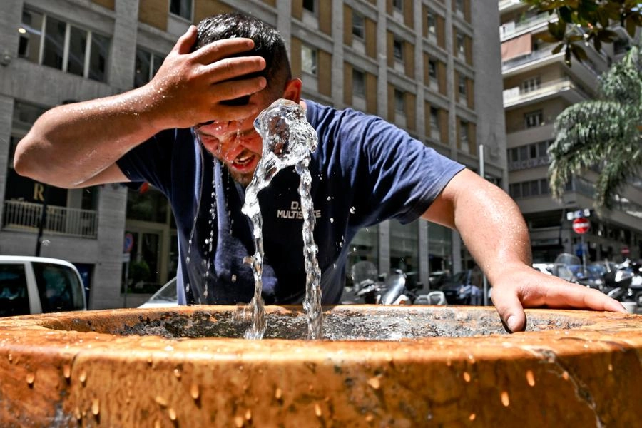 Un uomo cerca refrigerio bagnandosi a una fontanella (Ansa)