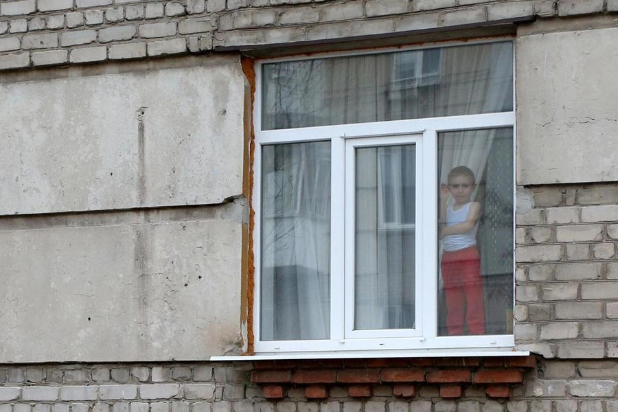 Un bambino guarda fuori dalla finestra a Severodonetsk