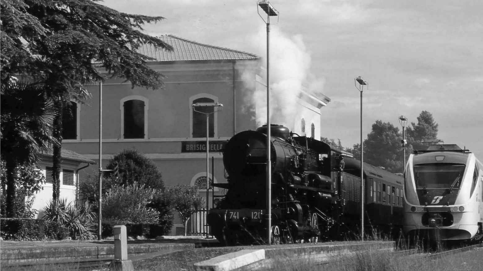 una foto della stazione di Brisighella con una locomotica a vapore e un 'Minuetto'
