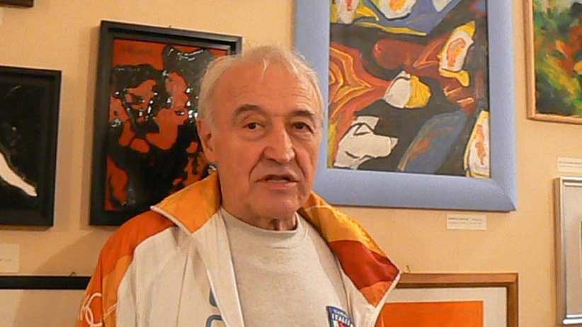 Oscar Ghidini davanti ad alcuni suoi quadri