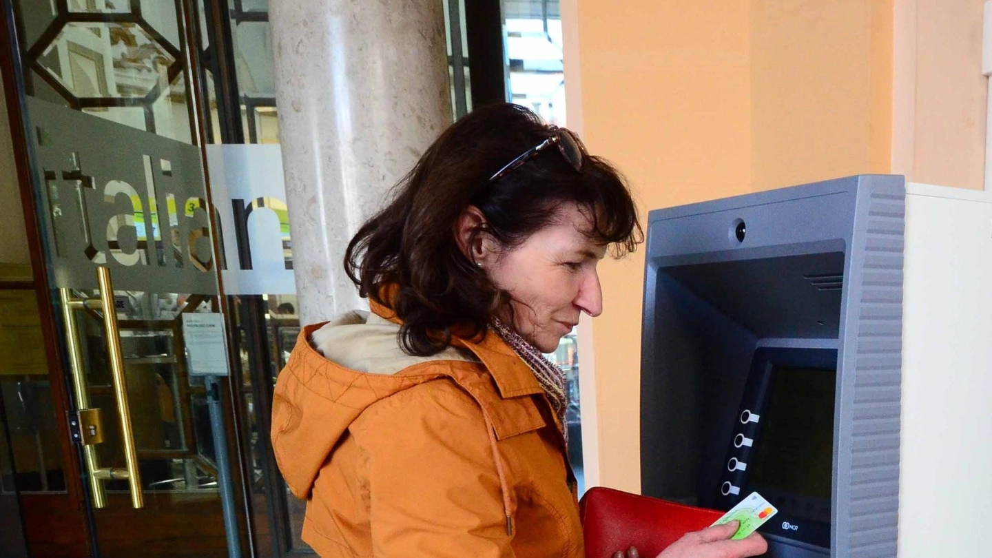 Una donna preleva  del denaro in un Postamat in città