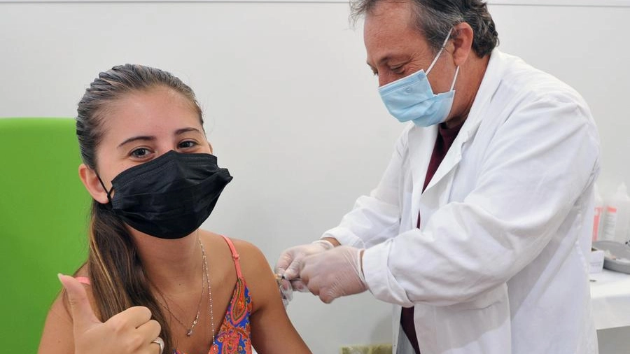 Una ragazza viene vaccinata da un medico all’hub del Mandela