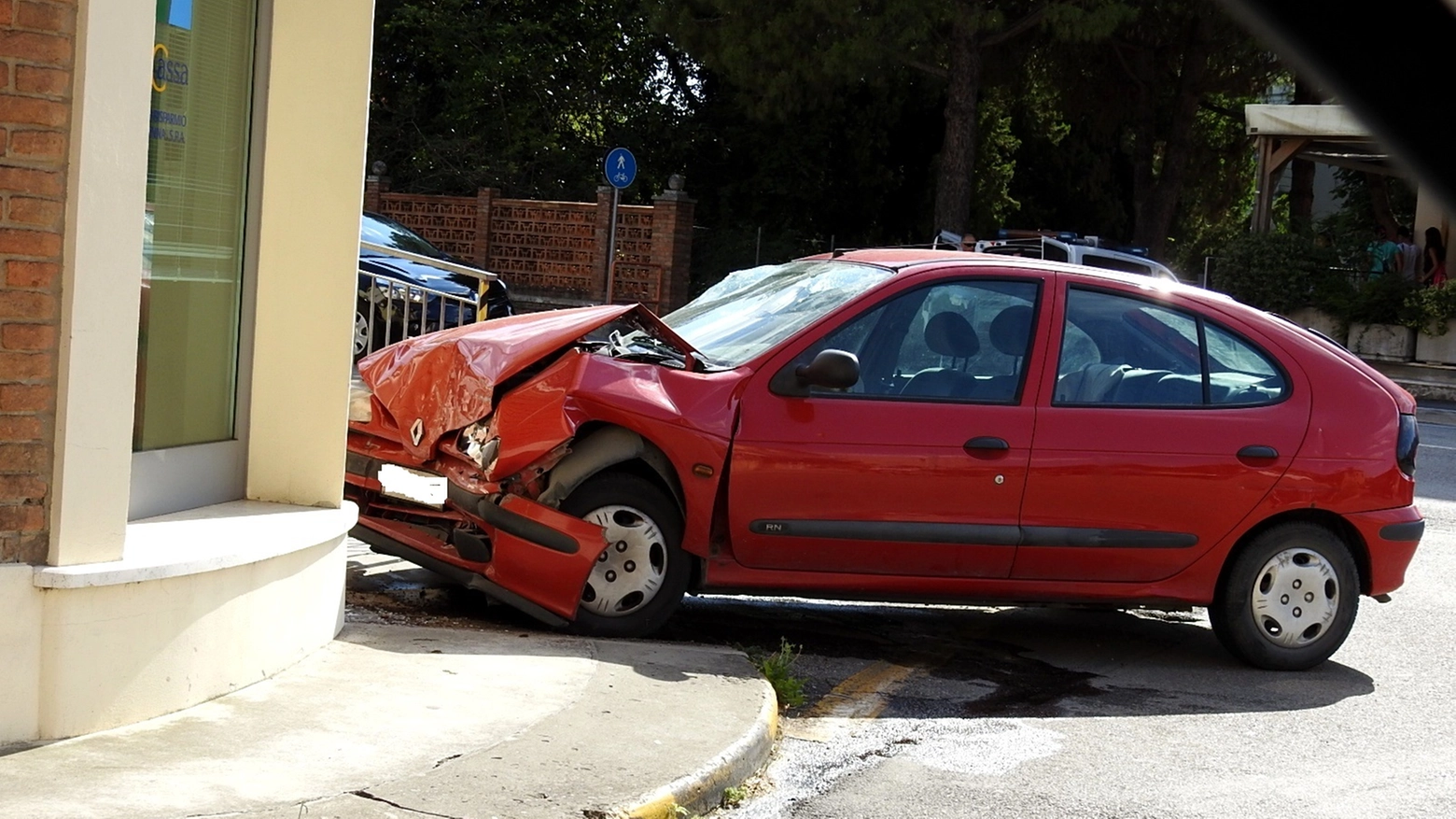 L'auto schiantatasi contro l'edificio che ospita una banca a Lavezzola (Foto Scardovi)