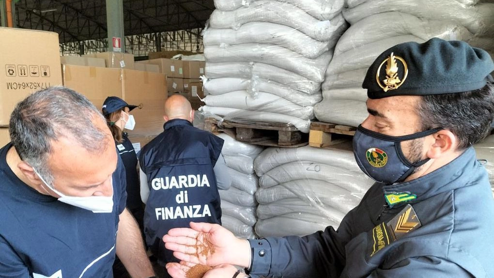 Militari della Guardia di Finanza mentre controllano in un porto un carico di cereali
