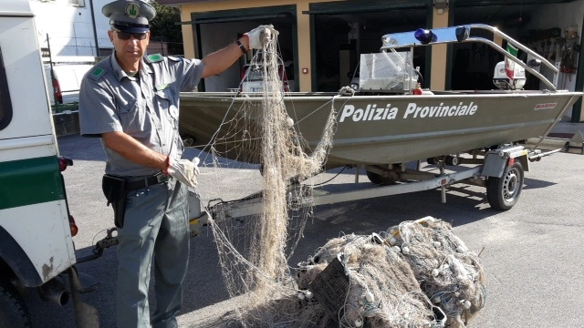 La polizia provinciale con le reti utilizzate per la pesca abusiva