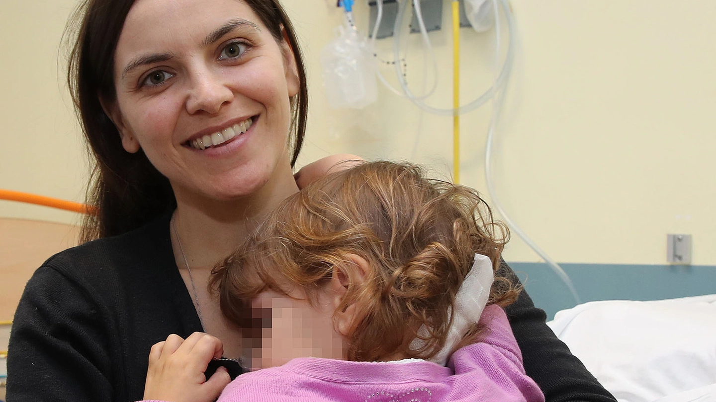 SORRISI Stefania con in braccio la piccola Chiara (nome di fantasia) dopo l’operazione che le ha salvato la vita (Fotoprint)