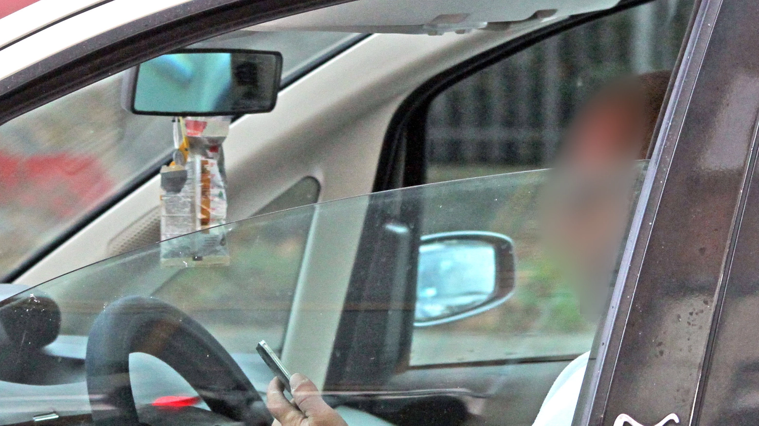 Un automobilista che controlla il telefonino (Foto Bove)