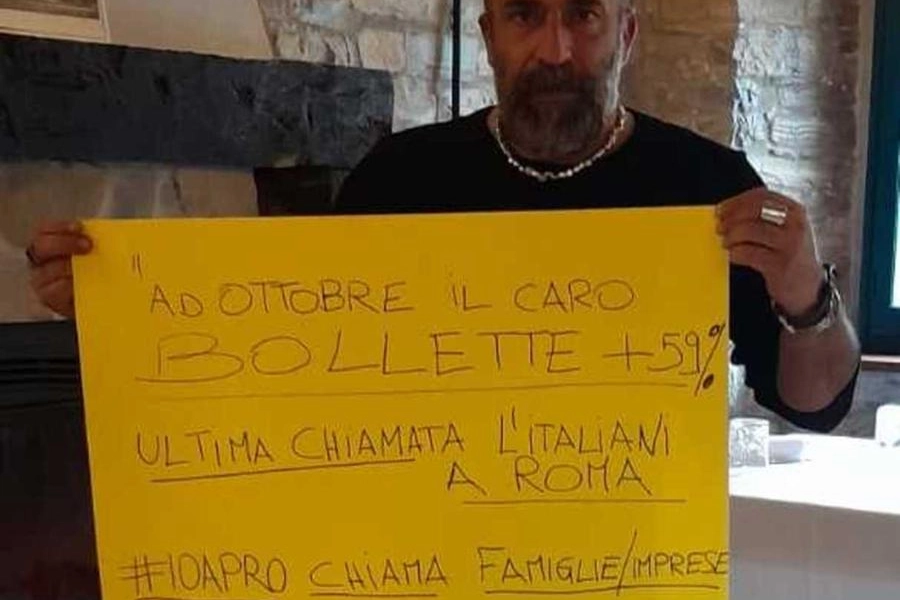 Maurizio Pace mostra un cartello di protesta nel suo ristorante Cà Poggioli. 
