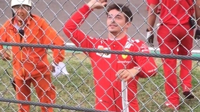 Leclerc restituisce il pennarello a un tifoso dietro le reti di recinzione