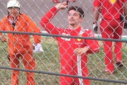 Leclerc restituisce il pennarello a un tifoso dietro le reti di recinzione