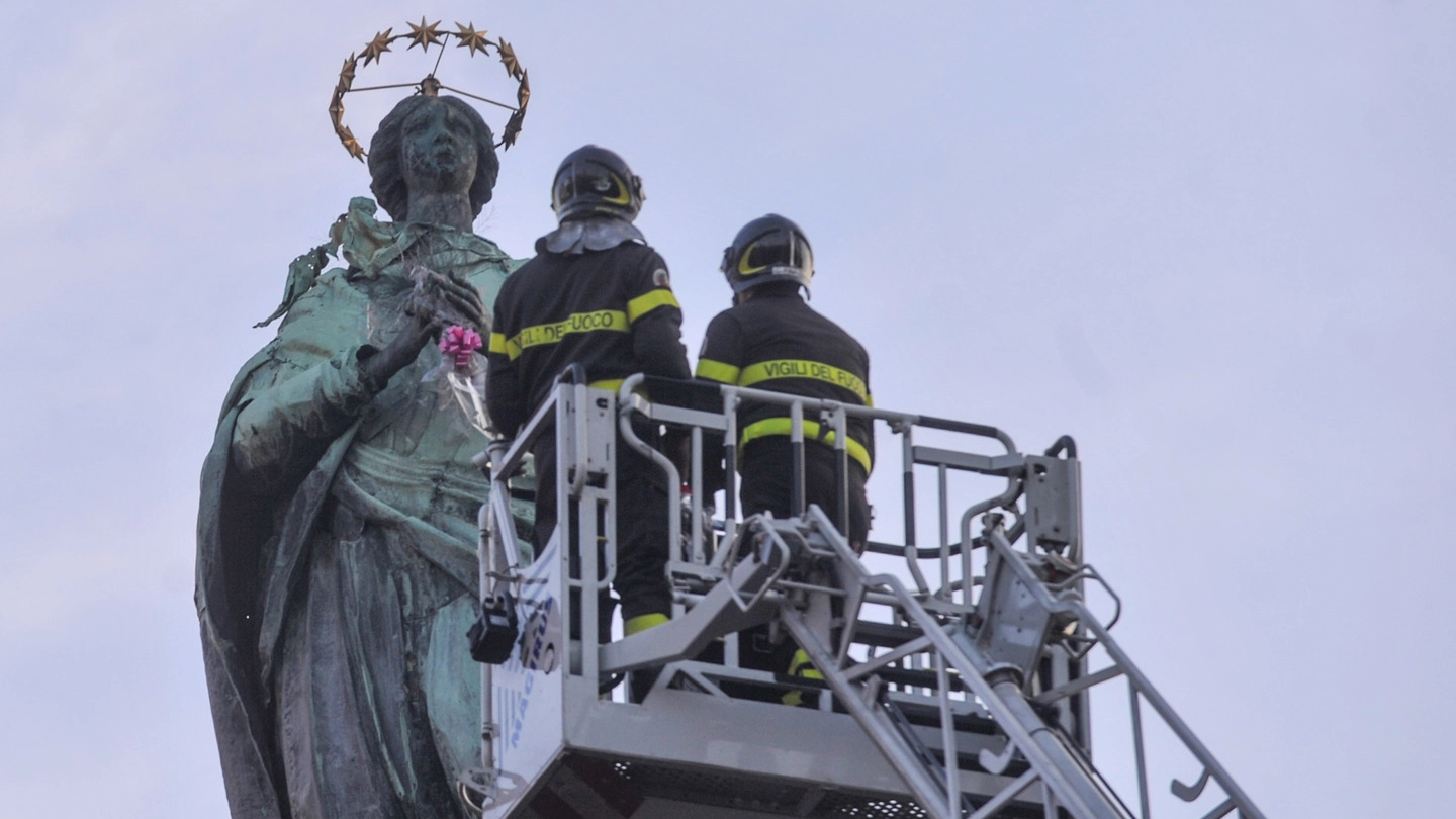 I vigili del fuoco donano i fiori alla statua della Madonna in piazza Malpighi (archivio)