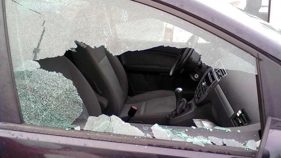 Riccione: il finestrino di un'auto in frantumi dopo la notte di follia dei vandali