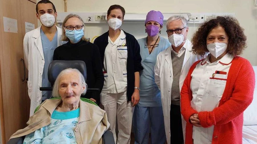 L'anziana curata in foto con i medici e gli infermieri