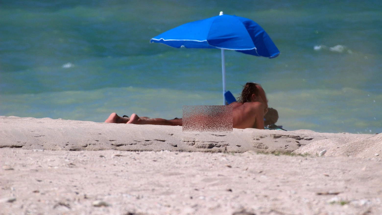 Uomo nudo in spiaggia in una foto d'archivio (Effimera)