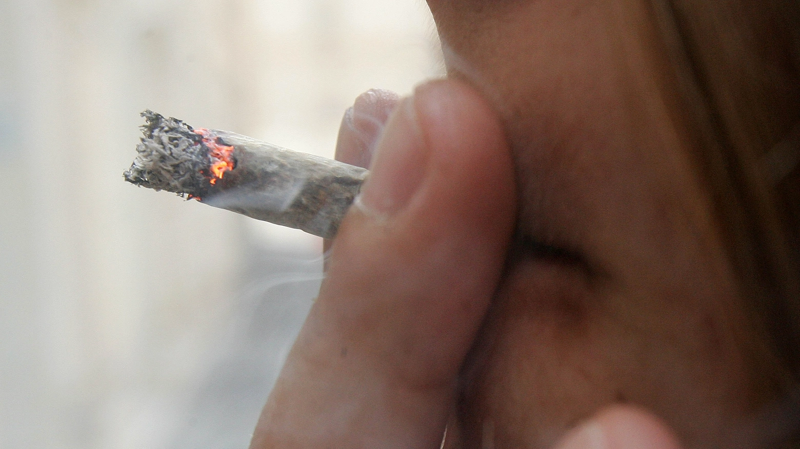Un giovane che fuma uno spinello (foto Ansa)