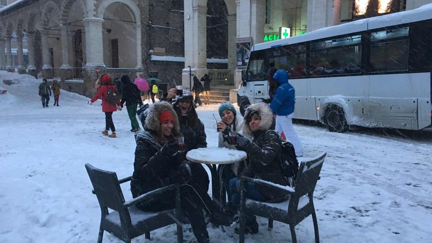Studentesse in piazza a Urbino si “godono la neve” con un drink (foto Pierucci)