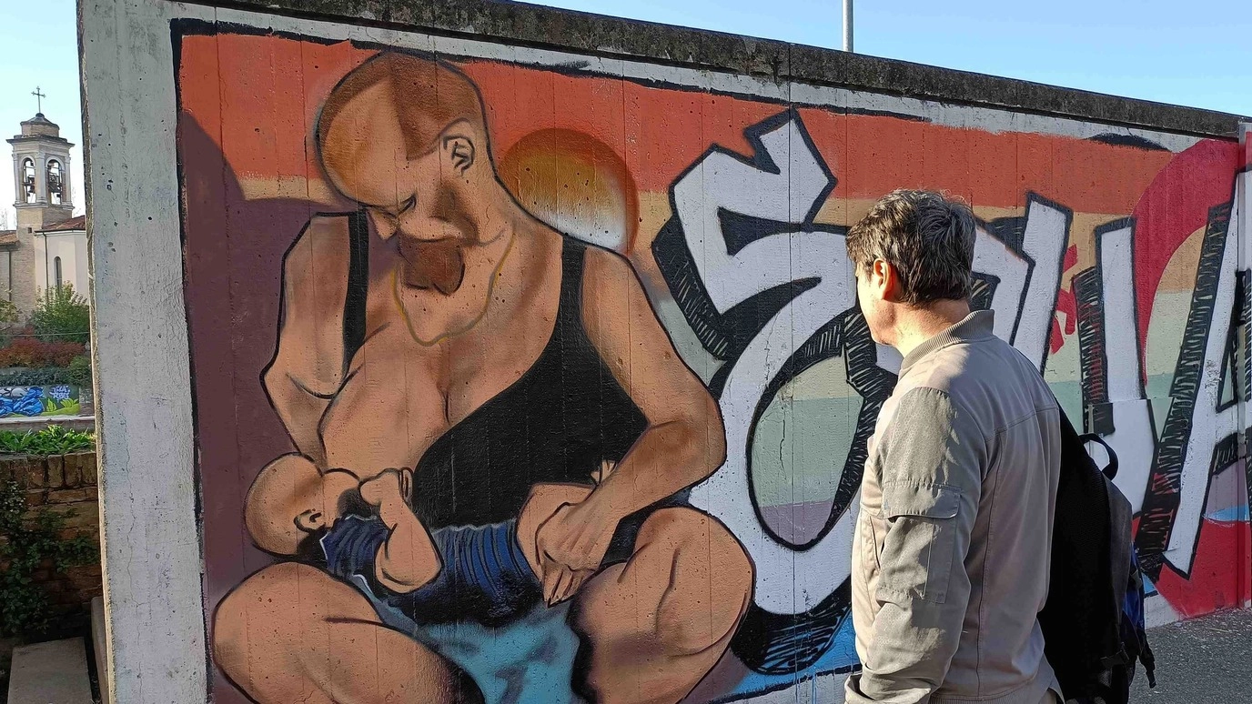 Il murales con un uomo che allatta a Rimini