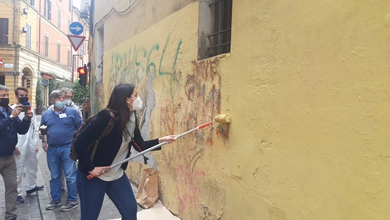 Isabella Conti pulisce i muri di via Petroni