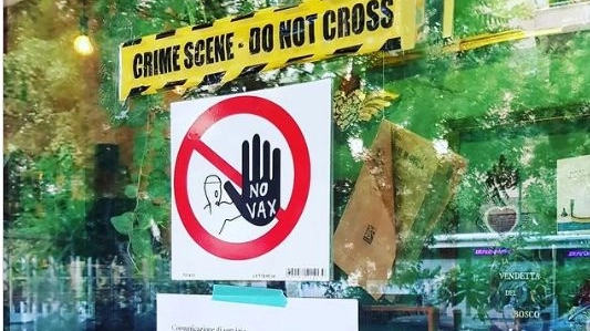 Il cartello "No vax" sulla vetrina dell'enoteca di Palermo