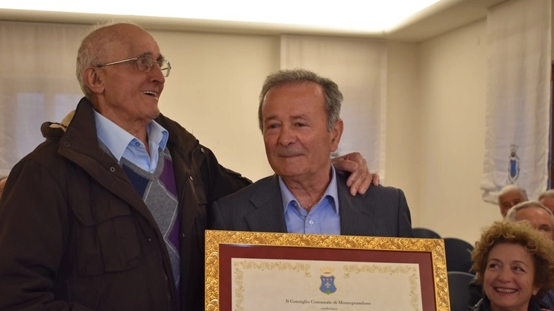 LA BENEMERENZA Fernando Capriotti abbraccia Francesco Giorgi che mostra il riconoscimento avuto dal comune di Monteprandone
