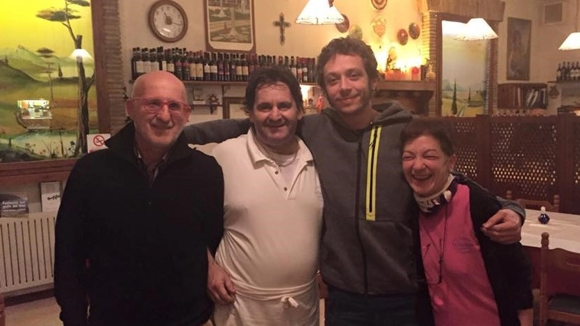 Marcello e Norina abbracciati a Valentino Rossi ospite del loro ristorante