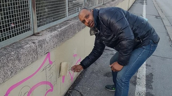 Ahmed Mahlah ripulisce i muri del ponte di San Donato imbrattati
